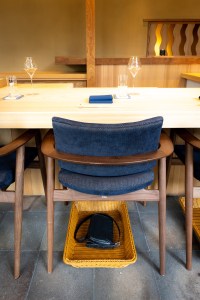 Shingo, a restaurant located in Coral Gables, offers convenient hand-woven baskets for people to stow their bags underneath their chairs. 