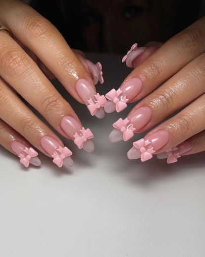 Long sheer pink nails with pink bow nail art charms