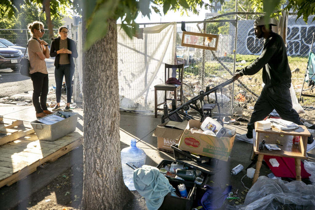 Cole Chandler (left), Mayor Mike Johnston's senior advisor for homelessness resolution, and at-large City Council member Sarah Parady talk during an encampment sweep on Stout Street, the first of Johnston's tenure. Aug. 4, 2023.