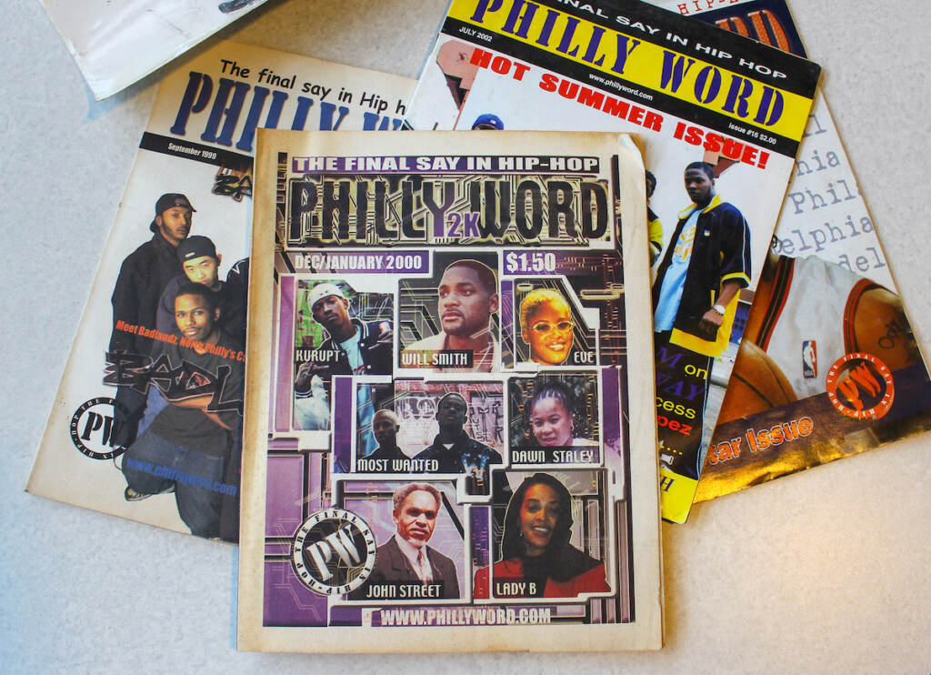 Several editions of Philly Word magazine are spread out across a table