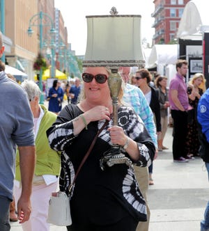 Jacqueline Harris of Sheboygan carries a lamp purchased at Retique Goodwill near the art show.