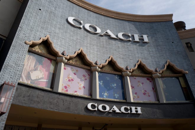 This photo shows a Coach retail shop in May, 2019 at the Citadel Outlets in Commerce, Calif. Tapestry, parent company of luxury handbag and accessories retailer Coach, is buying the owner of fashion brands including Michael Kors, Versace and Jimmy Choo, Capri Holdings.
