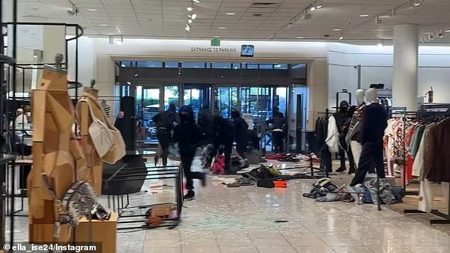The group swarmed the store at around 4pm on Saturday, scooping up armfuls of items, some inadvertently dropping amid the chaos, as they maneuvered around shattered glass and overturned mannequins