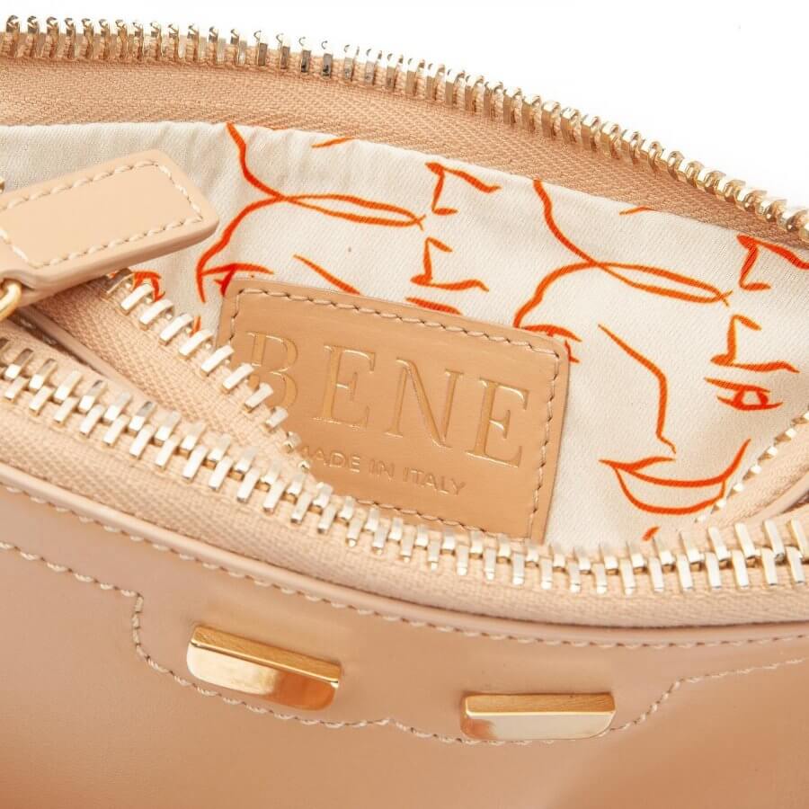 Tan BENE clutch bag with orange face drawing on the silk liner