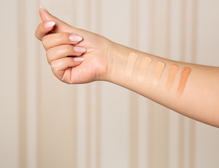 Woman applying concealer to wrist