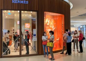 People queue to enter a store of luxury goods brand Hermes in Bangkok.