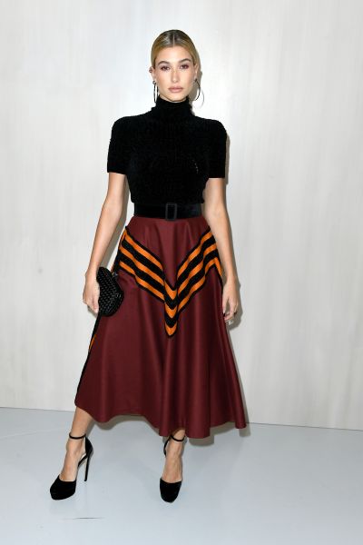 bieber wearing a black and maroon midi dress with orange stripes