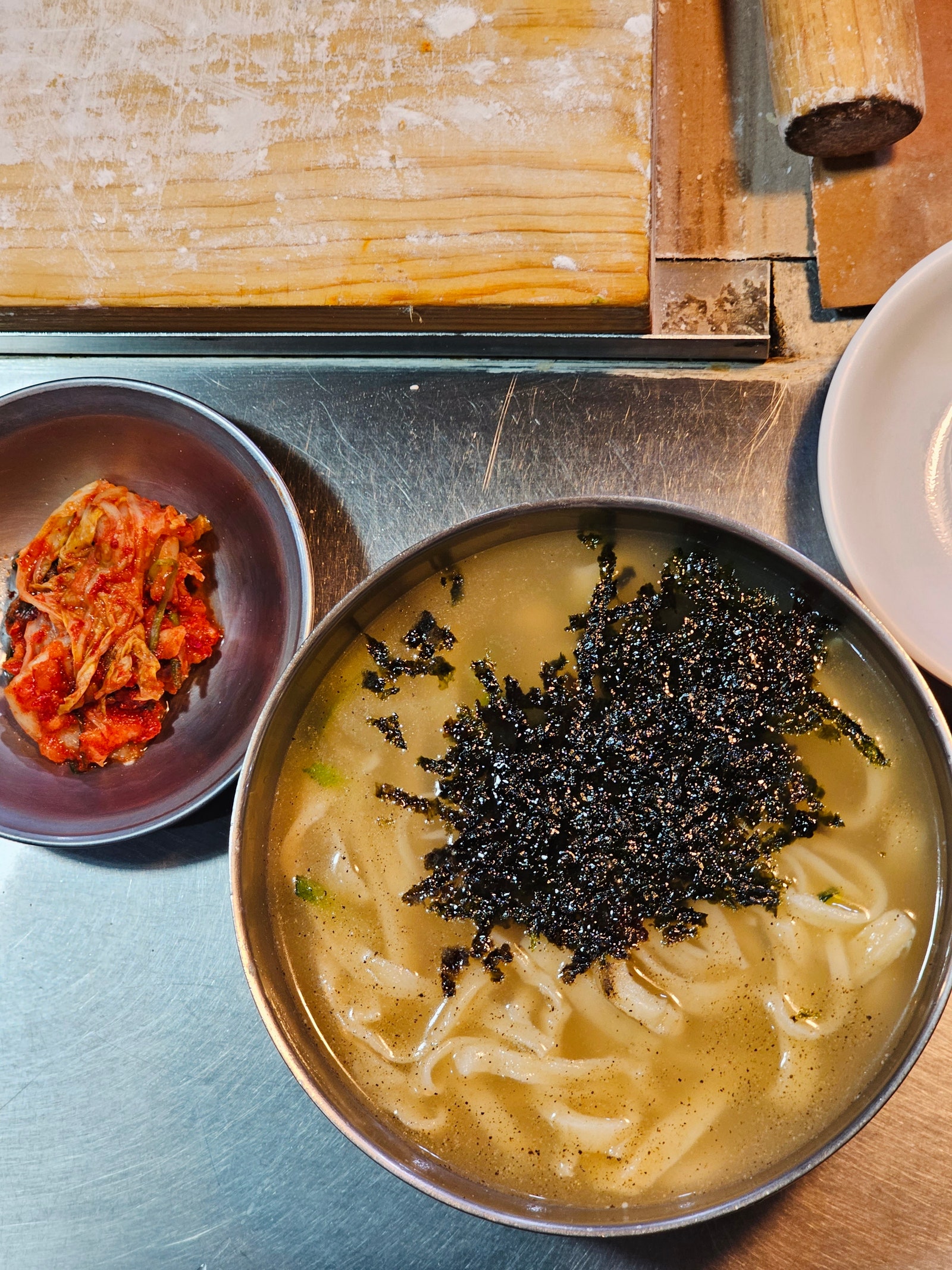 The famous Kalguksu knifecut noodles served with a side of kimchi at Cho Yonsoons stall in the Gwanjang market