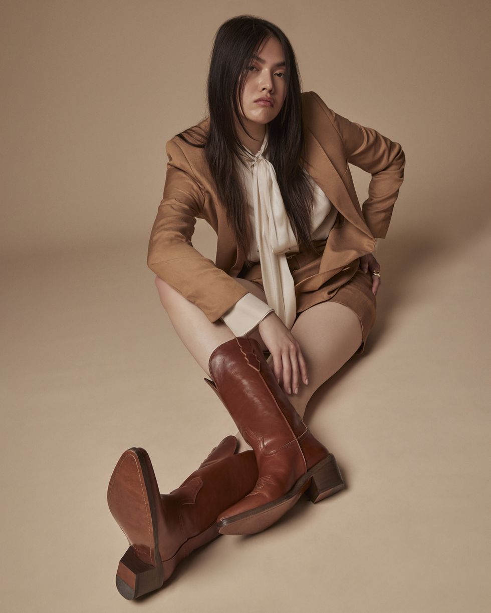 a model wears a pair of brown cowboy boots from partlo in a news story about the first partlow boots