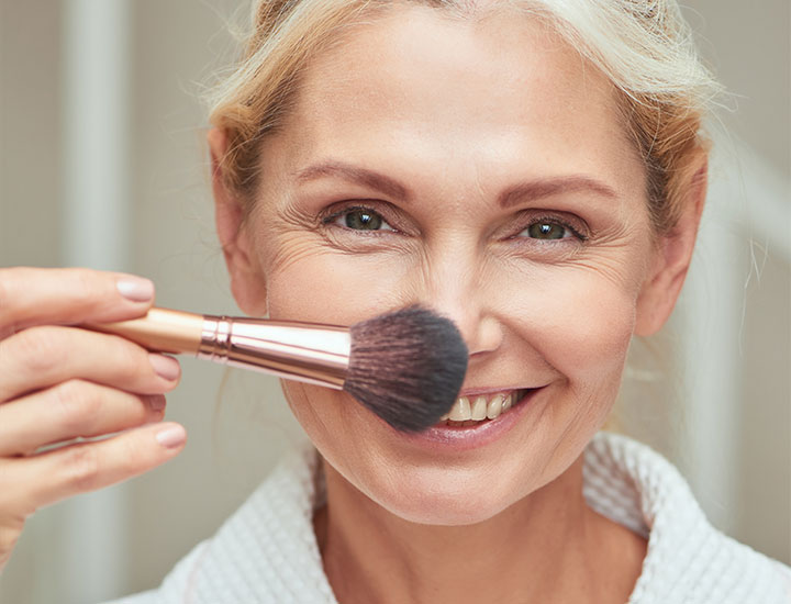 smiling-older-woman-makeup-brush