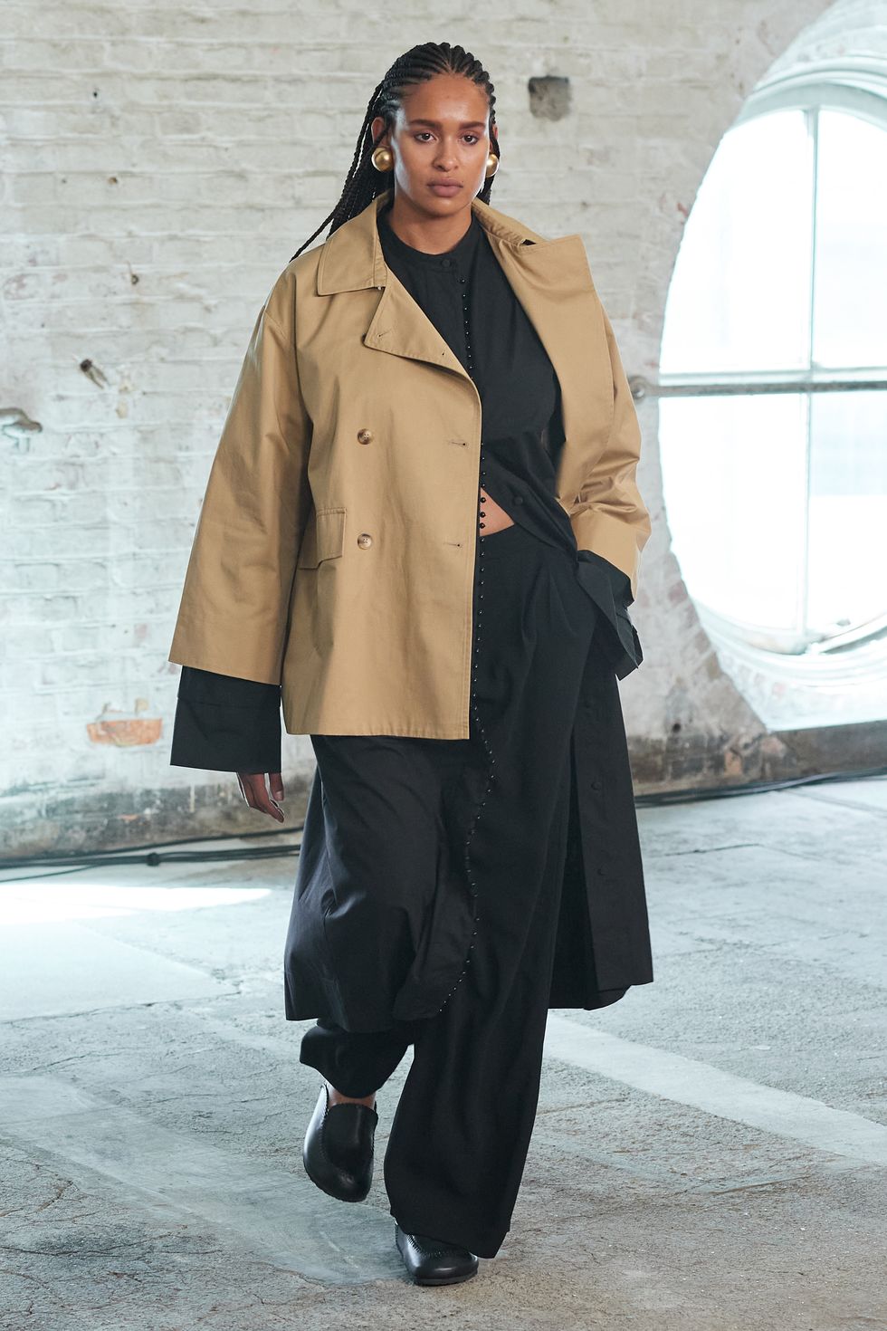 a model at lovechild 1979 wears a trench coat with black layers
