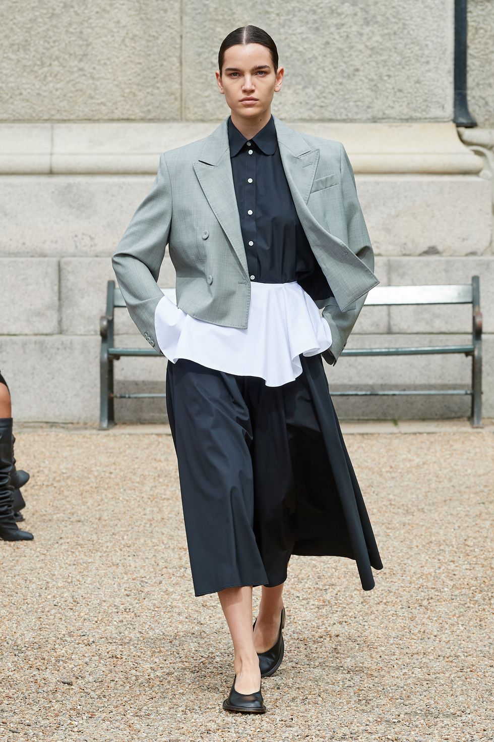 a model wears a suit with a peplum skirt in a guide to spring 2024 fashion trends