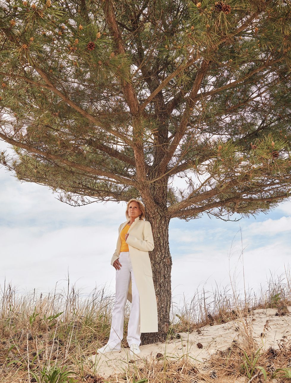 first lady jill biden standing in front of a tree outside, looking up at sky