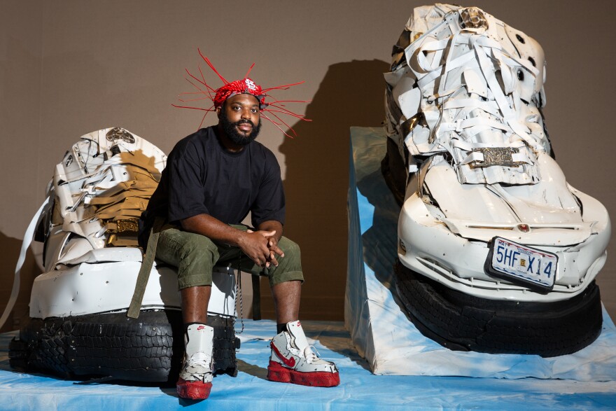 Artist Aaron Fowler is photographed alongside his sculpture “Live Culture Force 1’s, 2022” on Friday, Aug. 25, 2023, at the St. Louis Art Museum. Fowler’s work will be on display at the museum through the end of the year, as a part of its exhibit “The Culture: Hip Hop and Contemporary Art in the 21st Century.”