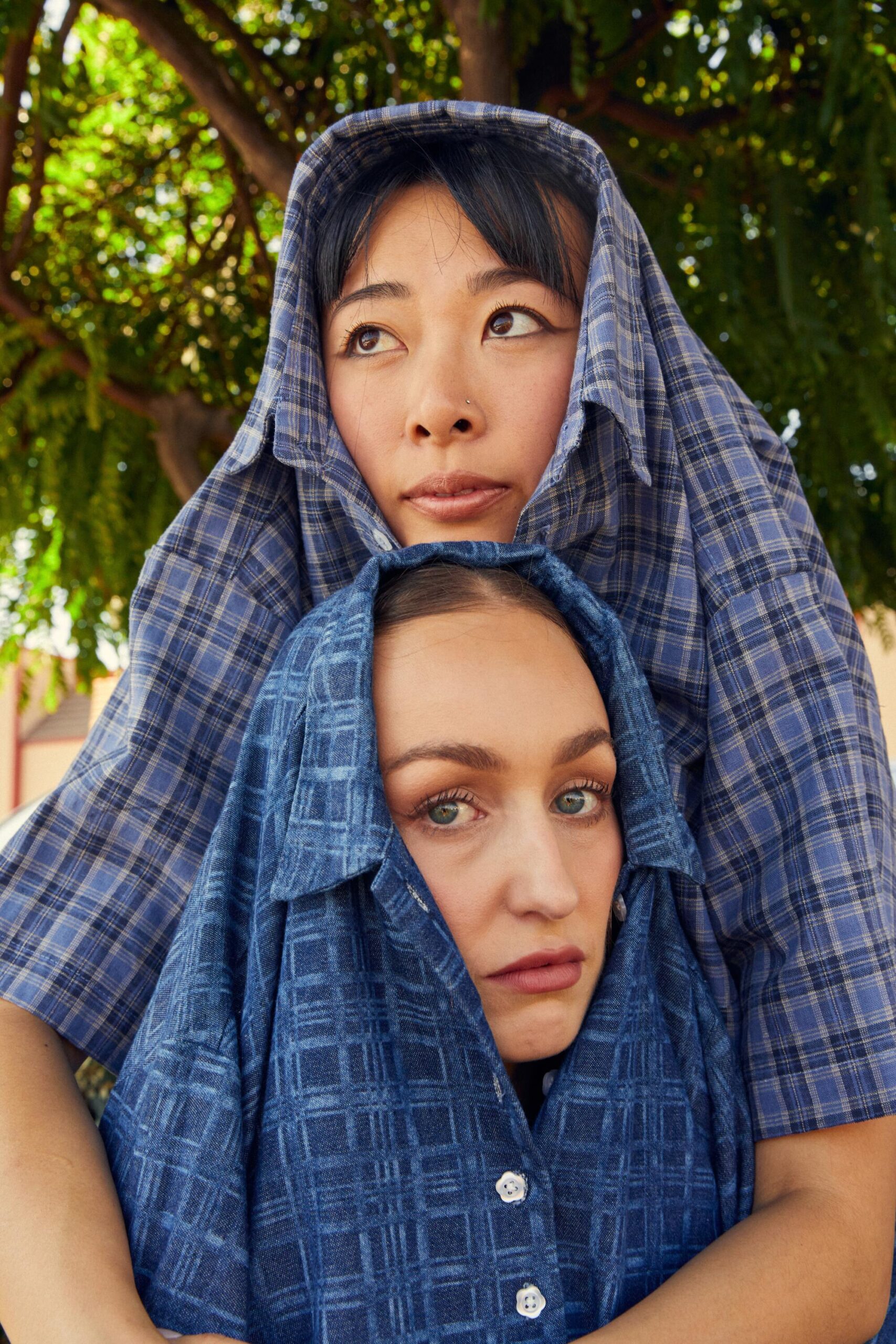 Two women, their heads one above the other peeking out of shirt necks.