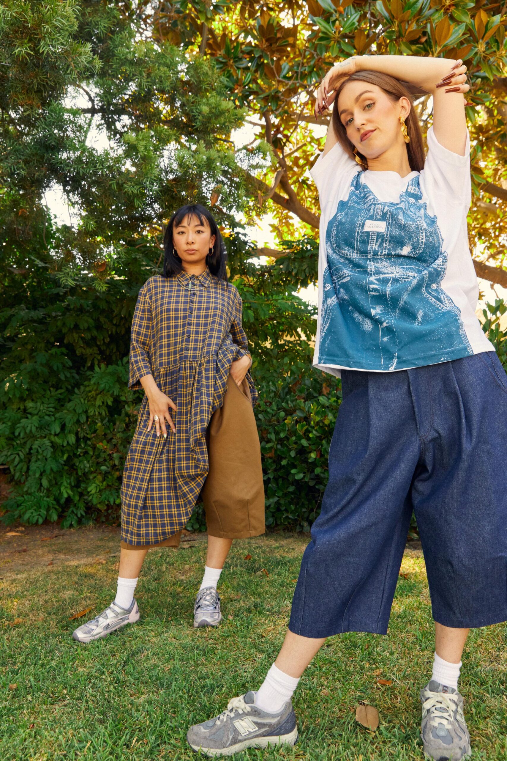 Two people stand outdoors wearing relaxed, oversized clothing