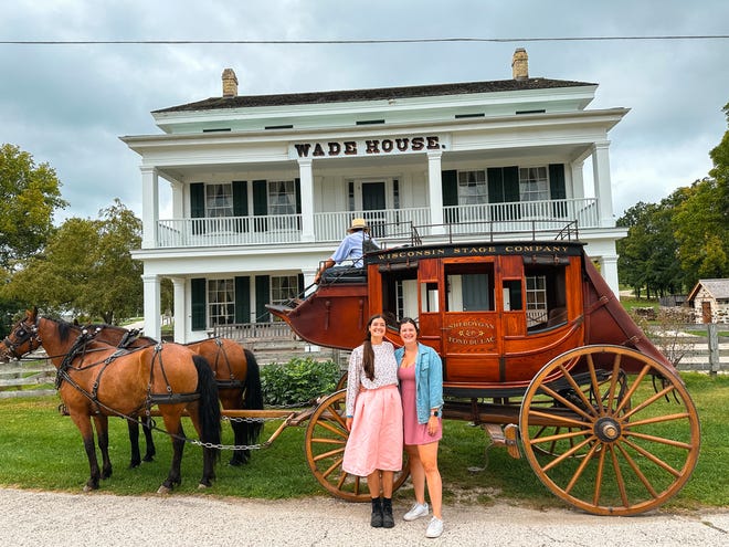 Sisters Haley Dolata, left, and Julia Silvers pose in front of a stagecoach at Wade House in Greenbush during a Wisconsin history road trip.