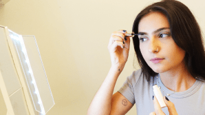 beauty editor applying Rare Beauty eyebrow gel, a best Rarre Beauty product