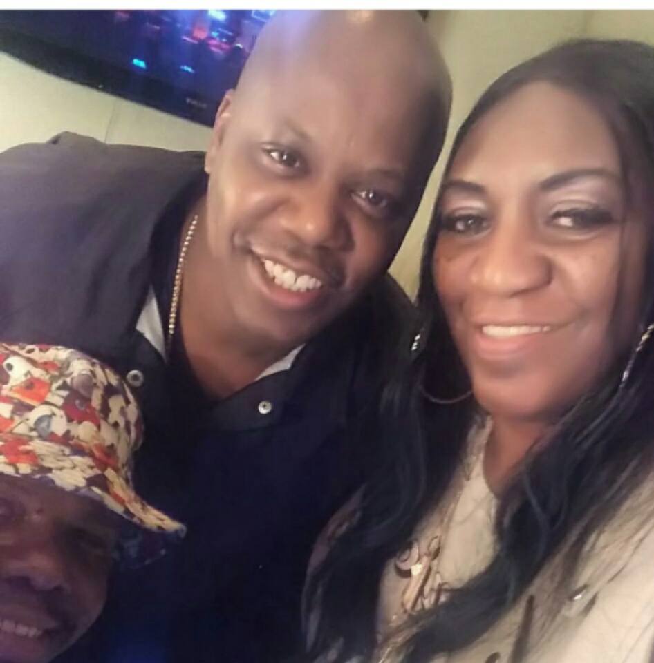 A Black man and Black woman pose for a selfie, smiling at the camera