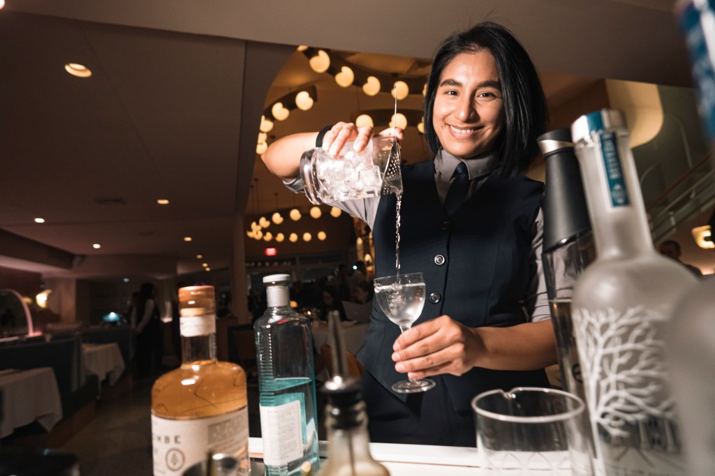 A bartender preparing an alcoholic beverage. 