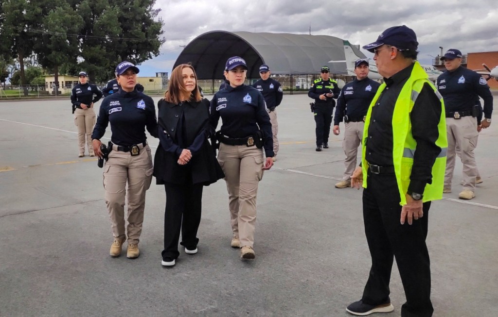 Nancy Gonzalez (center) being escorted to a private flight from Colombia to Florida on Wednesday.