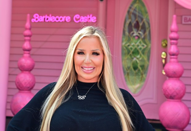 Brooke Fleetwood in front of a pink house with a sign that says 