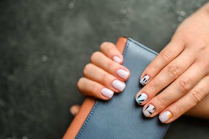 Women's hands with the colorful pattern on the nails for fall