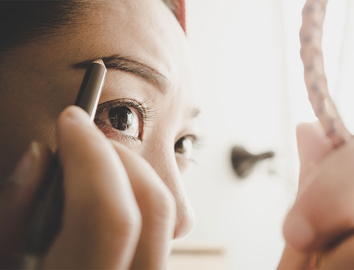 woman-putting-on-eyebrow-makeup
