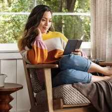 Woman reading Amazon Kindle Paperwhite Oasis e-reader