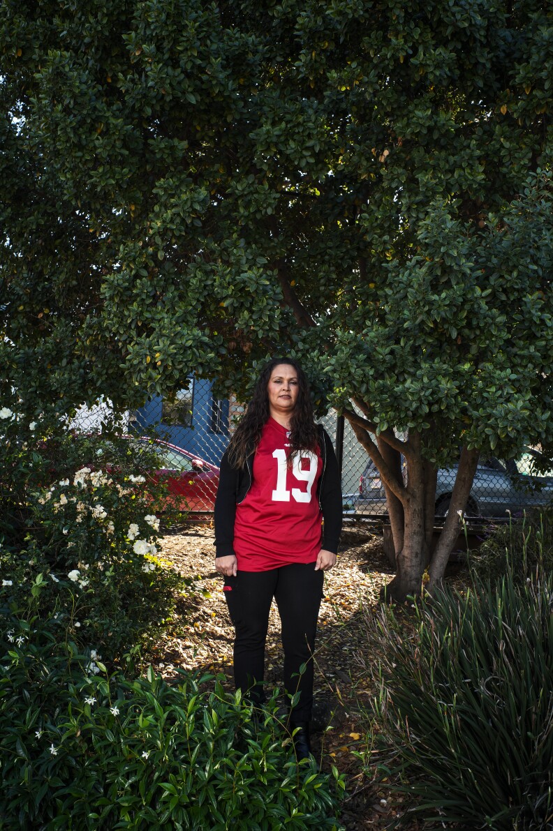 A woman with light-tone skin and dark hair wears a red jersey with 19 on the front