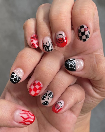 A trendy checkered nail design for 2023 that includes flame black nail art, smiley faces, and flower...