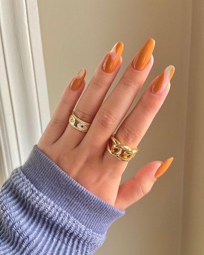 Burnt orange negative space nails are a subtle pumpkin-inspired nail art design idea for fall 2023.