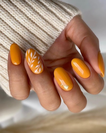 Orange nails with botanical print.