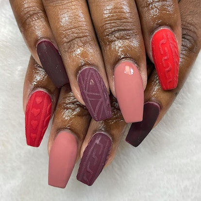 If you need a winter manicure design idea for 2023, these purple, mauve, and red sweater nails are o...