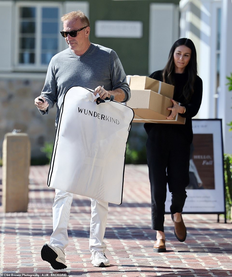 SHE did the heavy lifting: The unnamed woman held onto two brown gift wrapped boxes with satin ribbons