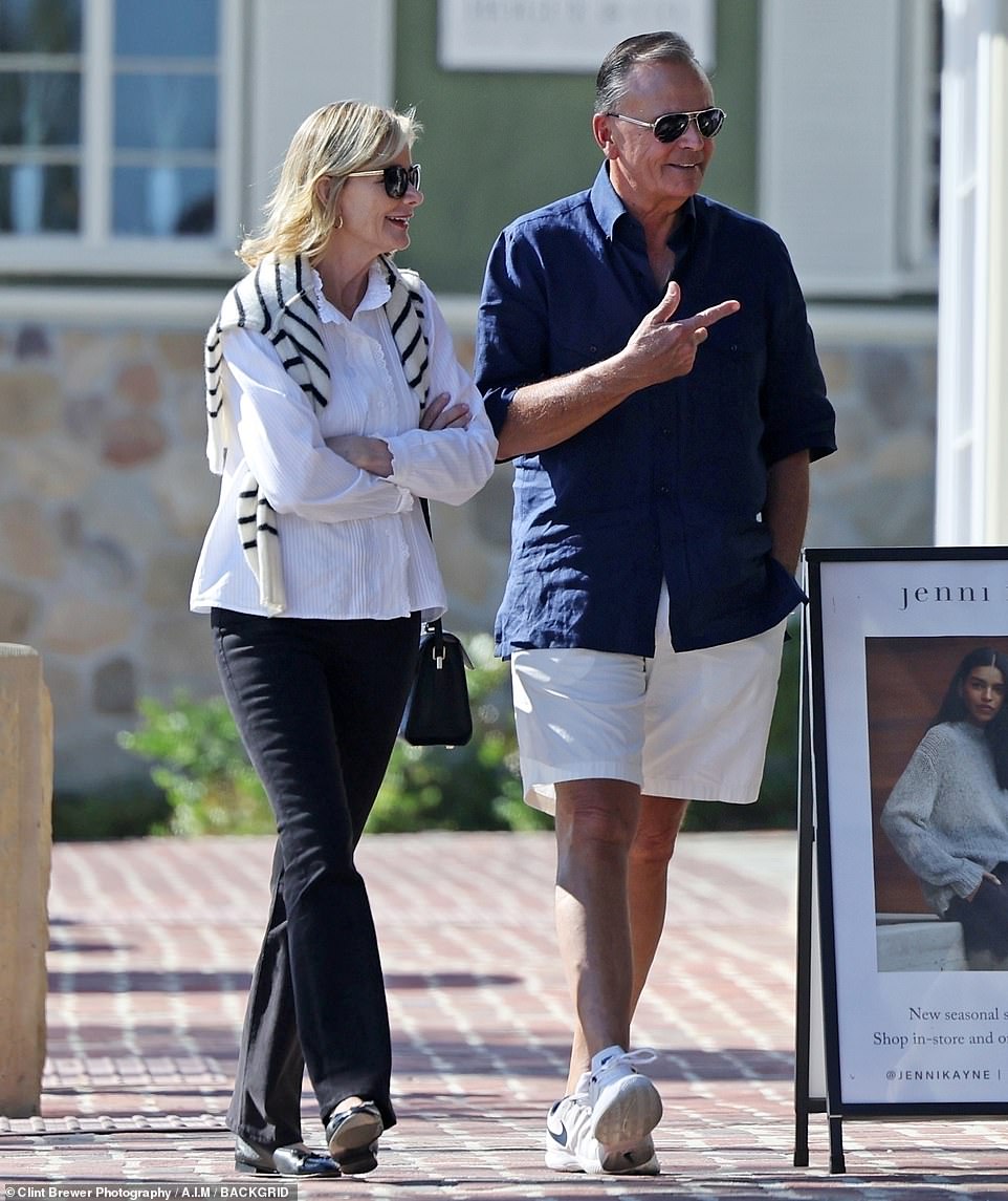 With his elegant wife: Rock wore a blue shirt and shorts while his spouse modeled black and white