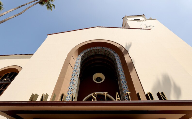 An exterior, close up view of the front of Union Station with its lettering that reads Union Station underneath a curved arch.