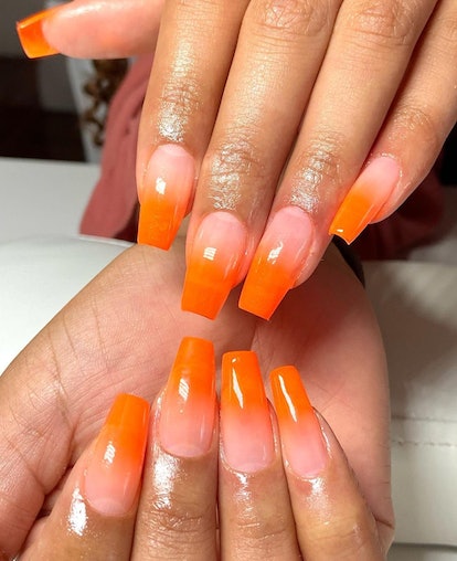 Orange ombre tips are a subtle pumpkin-inspired nail art design idea for fall 2023.