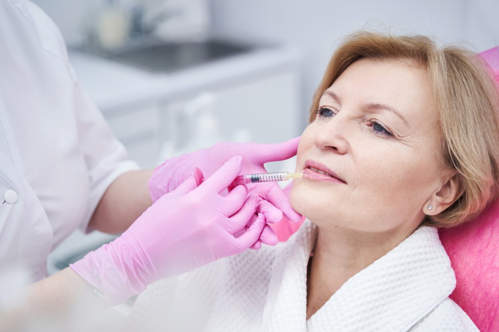 Mature woman receiving lip filler for thin lips