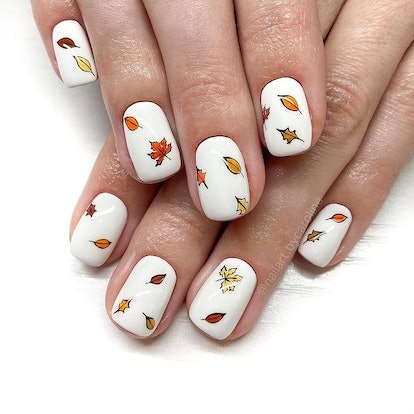 White nails with minimalist leaf designs.