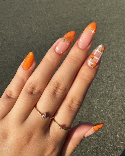 Orange French tips are a cute pumpkin nail art design idea for fall 2023.