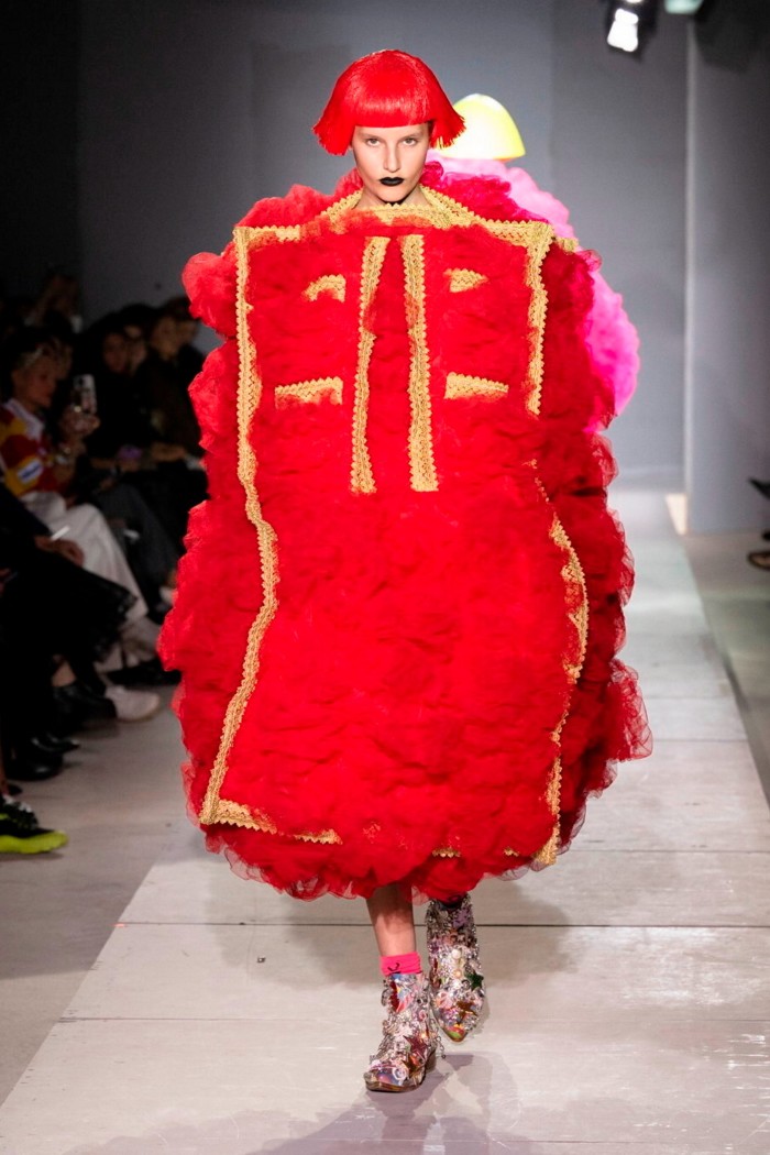 A model is a huge fluffy bright red outfit