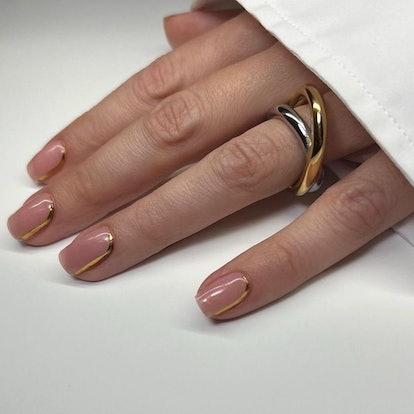 Understated gold chrome nail cuffs are a simple & on-trend Thanksgiving 2023 nail art design.