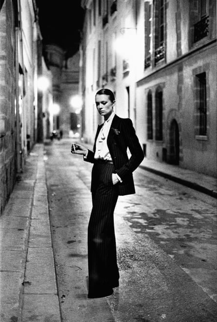 Black and white photo of a model wearing Yves Saint Laurent’s Le Smoking suit on a Paris street, 1975