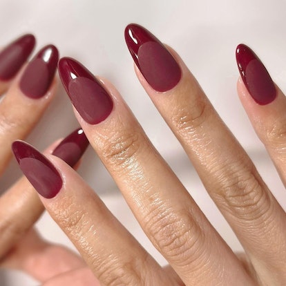 Monochromatic cranberry red French tips nails are an on-trend Thanksgiving nail design for 2023.