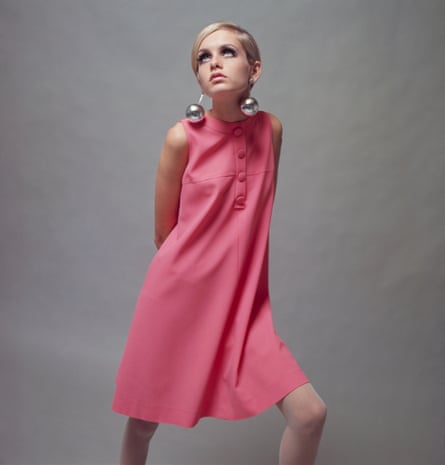 British model Twiggy in  a pale pink mini dress and large bauble earrings, December 1966