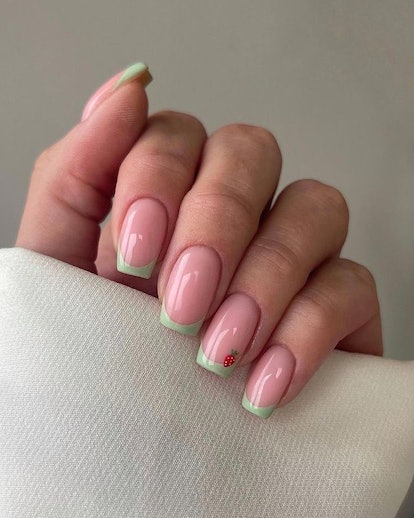 Matcha nails with strawberry detail.