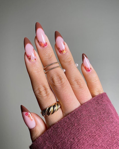 Brown French tip nails with fall floral details are an on-trend nail art design for Thanksgiving 202...