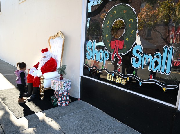 Tasa Kent, 2, walks up to meet Santa during the Rise and Redemption 5th Annual Small Business Saturday in downtown Vacaville. (Chris Riley/The Reporter)