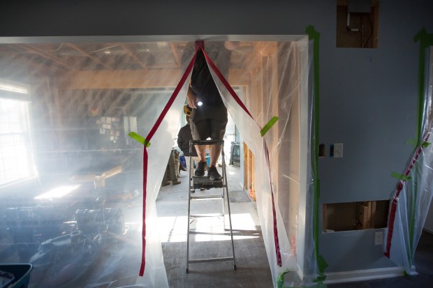 Trey Witten with Tidewater Pro Build, Tuesday, Oct.3, 2023 as he cuts a channel in the ceiling of Laurie Wood's home for the wiring of a smart system that will allow Wood to control various things in the home including the front door using her phone. Wood has been in a wheelchair for the past 11 years due to a training accident while a member of the Norfolk Sheriff's Office. She has lived in her Virginia Beach home for the past 20 years and since her accident some of her home has been inaccessible to her. Tidewater Pro Build of Suffolk is renovating the home of the Navy veteran for free to make the entire home wheelchair accessible. Bill Tiernan/ For The Virginian-Pilot